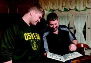 Matthew Schomber ’88 showed a yearbook to his son Eric ’19, an accounting major.