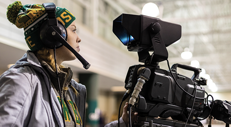 Tara O'Donovan operating a camera at SUNY Oswego men's ice hockey