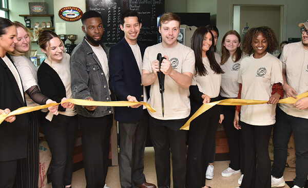Students in SUNY Oswego’s Management 444 class hold a ribbon-cutting ceremony during an April 11, 2023, grand opening for the new Rich 'N’ Pour Café in the Rich Hall lobby. The class serves as a board of directors for the new student-led, student-run café, which serves Finger Lakes Coffee Roasters-infused beverages and baked goods in a relaxing ambience that can also serve as a welcoming meeting space in the home of Oswego’s School of Business.